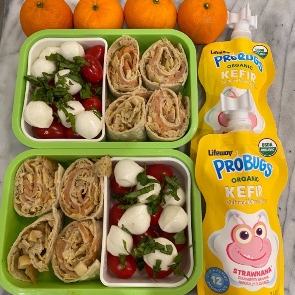Flavorful basil on top of a tomato-mozzarella salad in a kid's lunchbox