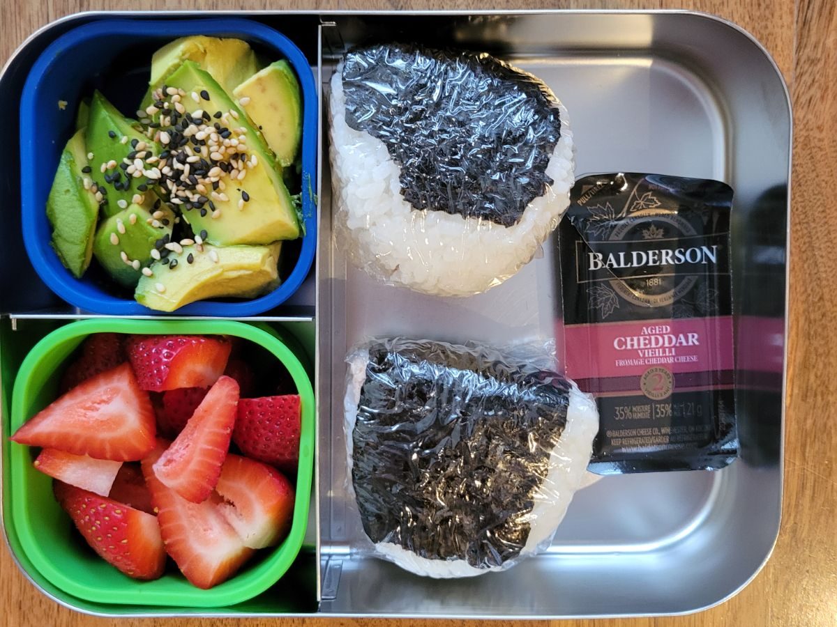 Stainless steel Lunchbots bento lunchbox with classic tuna mayo triangle onigiri, perfect kid-friendly Japanese rice ball idea for school lunches or picnics.