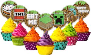 A colorful display of cupcakes topped with vibrant frosting in pink, orange, and yellow, decorated with Minecraft-themed decorative picks featuring motifs like TNT, a Creeper, and block textures.