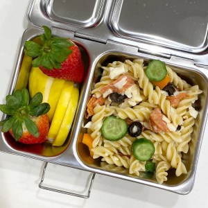 Pasta salad with chicken, cucumber, and other veggies, in a stainless steel Planetbox bento lunchbox for a kid's lunch at school