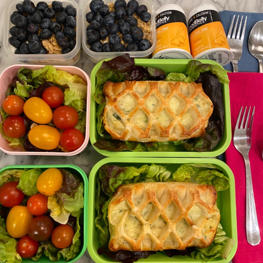 French-style lunch for kids with delicious leek friand on a salad bed in a lunchbox