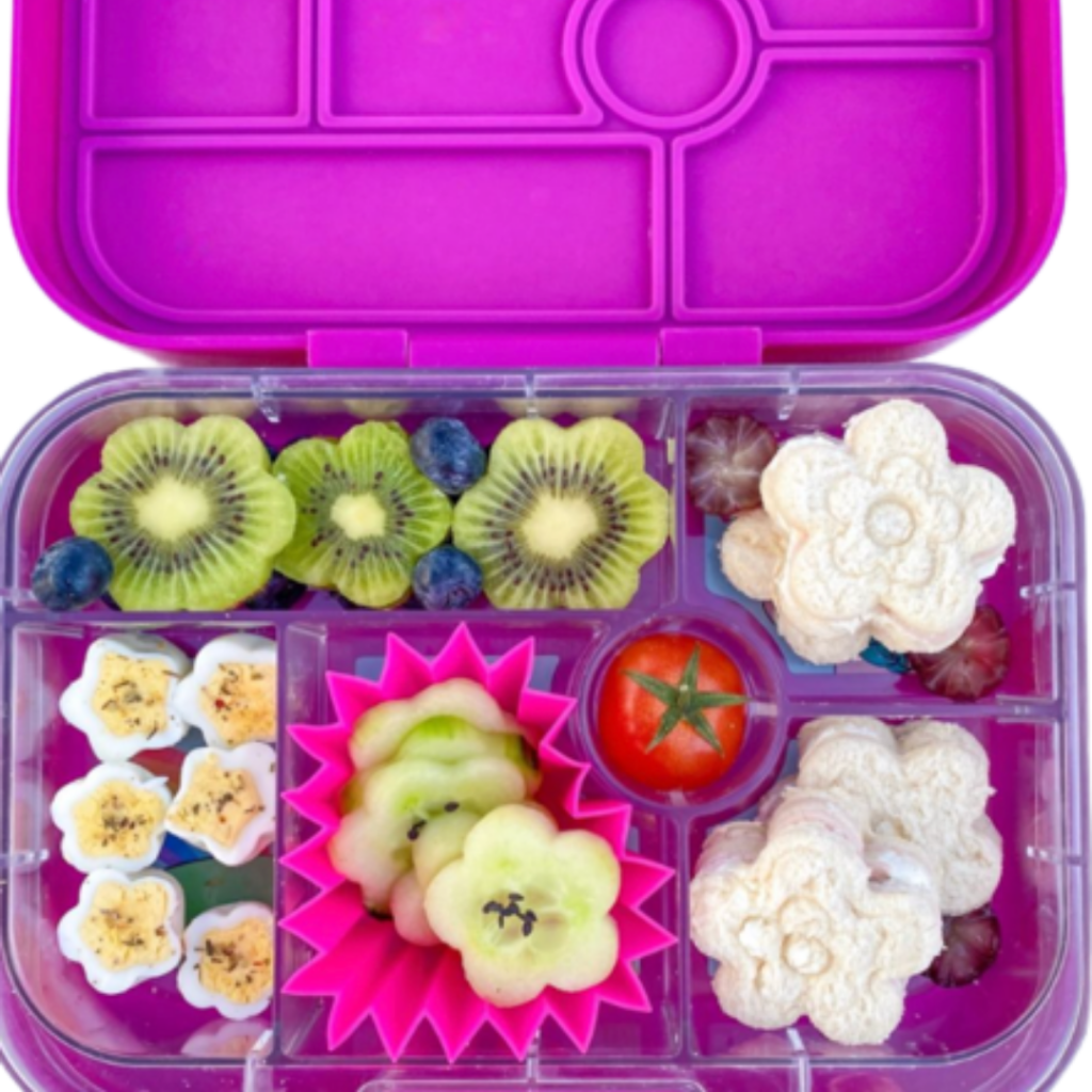 a beautiful Flower Power lunchbox using food cutters for fruits (kiwis), veggies (cucumbers), sandwiches, and eggs!