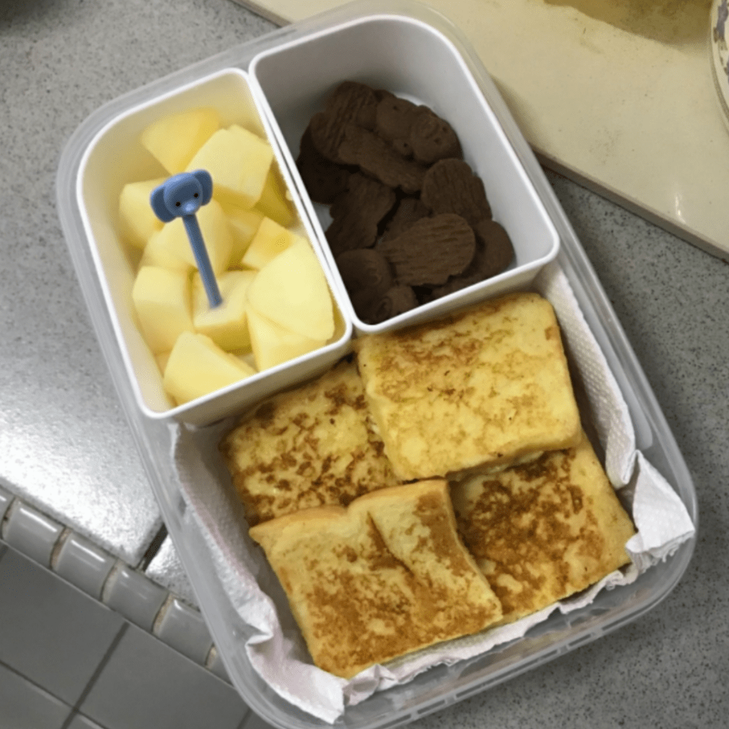 French toast with apple and cookies in a kids snack box.