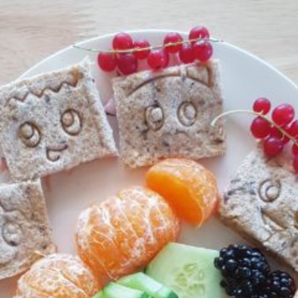 Ham sandwiches with fruits and veggies for a kids snack box.