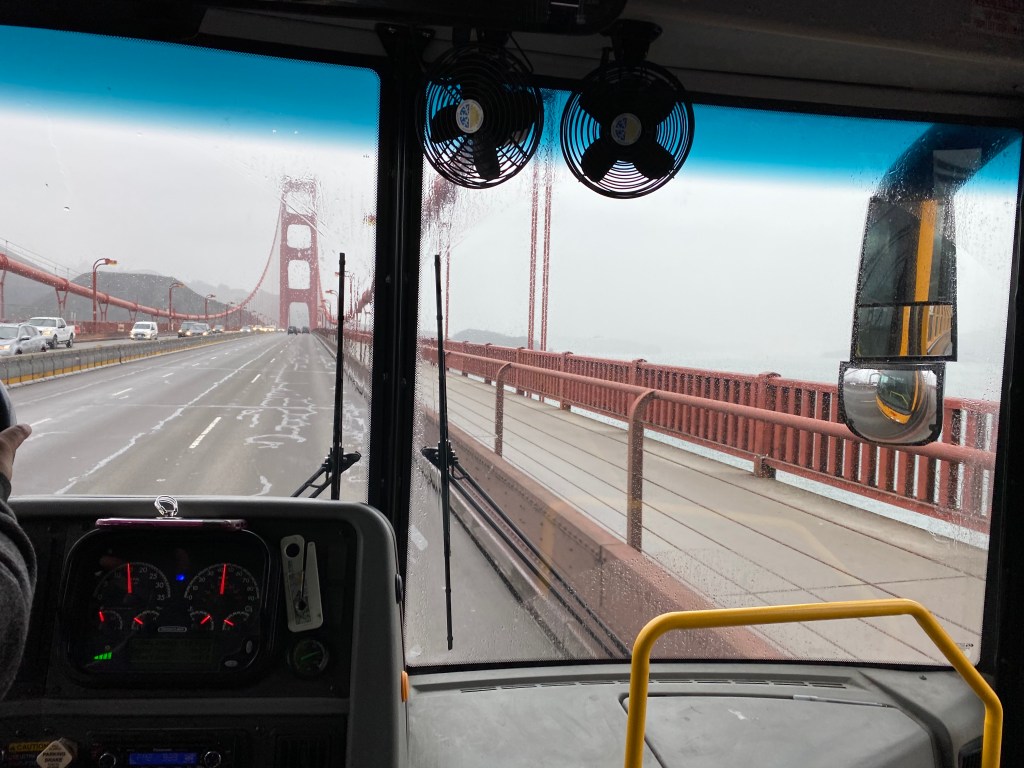 Yellow Bus crossing Golden Gate Bridge on a rainy day