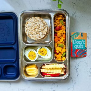 Snack box idea with hard boiled eggs, rice cake, crackers, and apple fr
